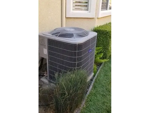 A large air conditioner sitting outside of a house.