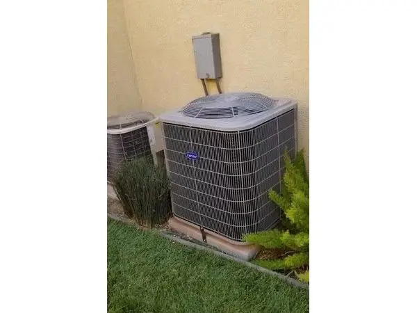 A large air conditioner outside on the grass.