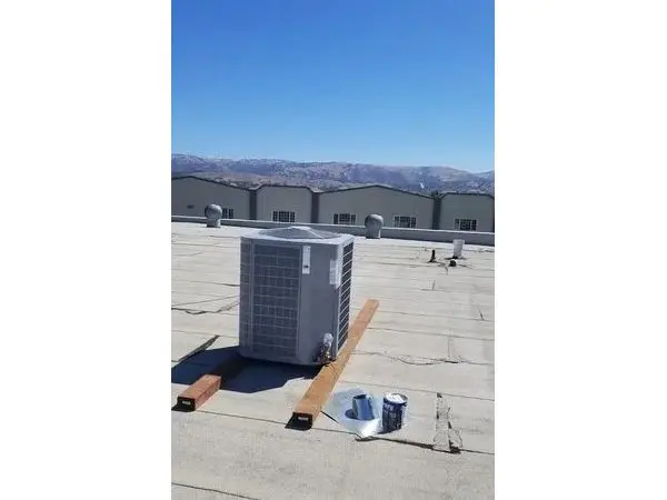 A large air conditioner on the roof of a building.